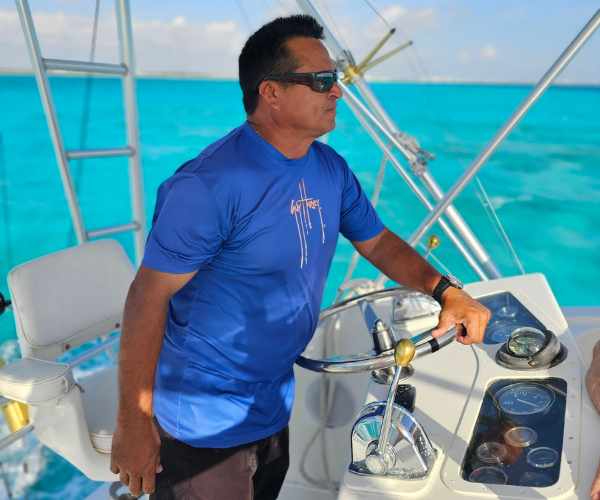 view of captain of cancun charter fishing boat at steering wheel