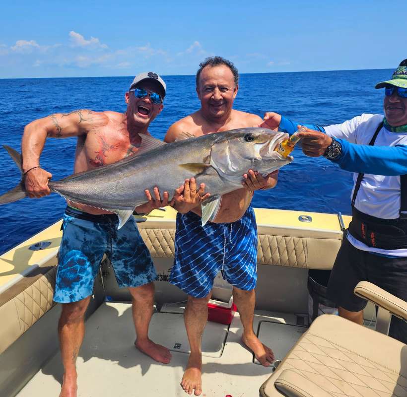 two men holding big game fish caught on sportfishing trip while in Quintana Roo Cacun